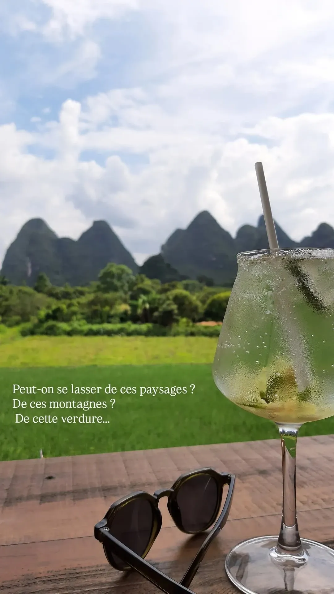 Cocktail on wooden table overlooking Yangshuo's karst mountains