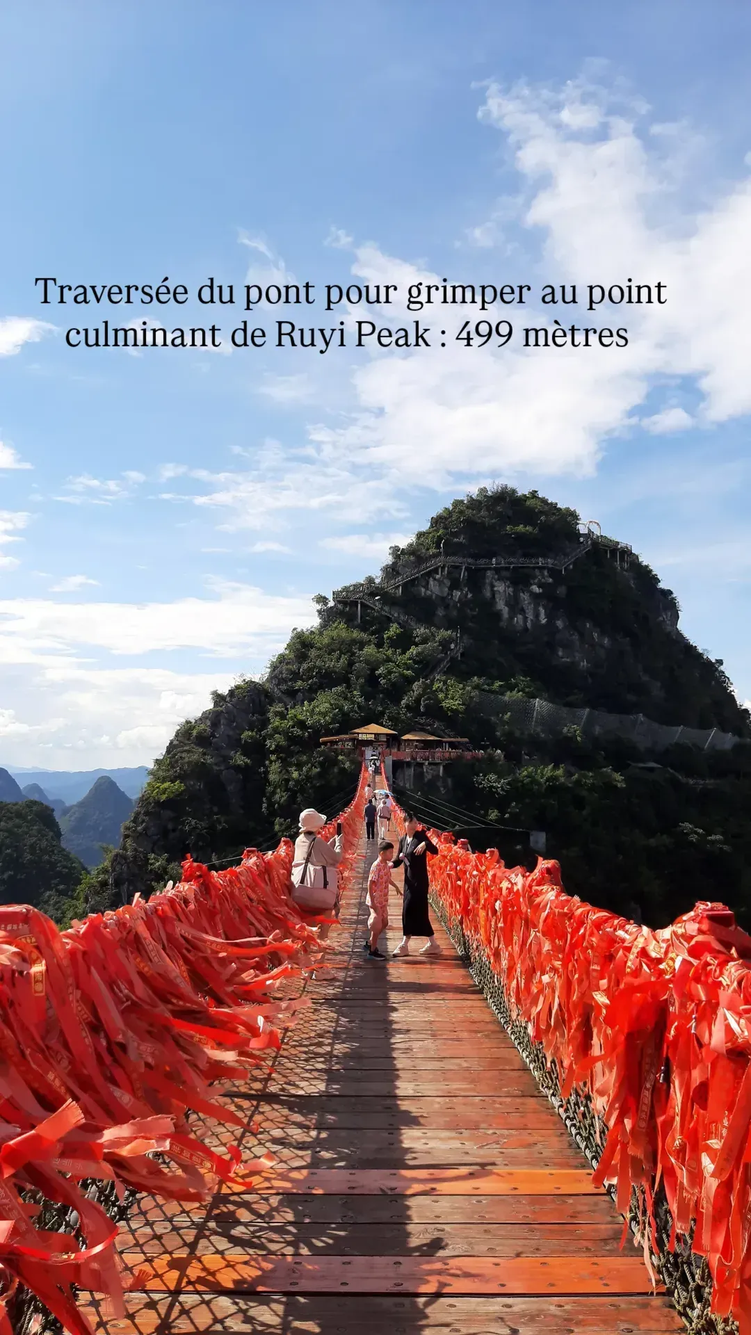 Visitors crossing the suspension bridge to the 499-meter summit of Ruyi Peak in Yangshuo, China