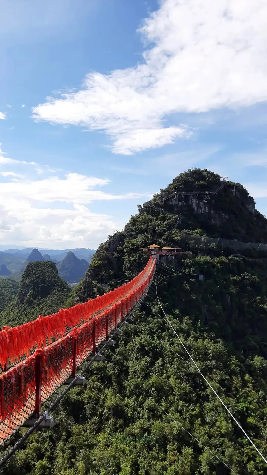 Aerial view of the red suspension bridge connecting karst peaks at Ruyi Peak, Yangshuo, China