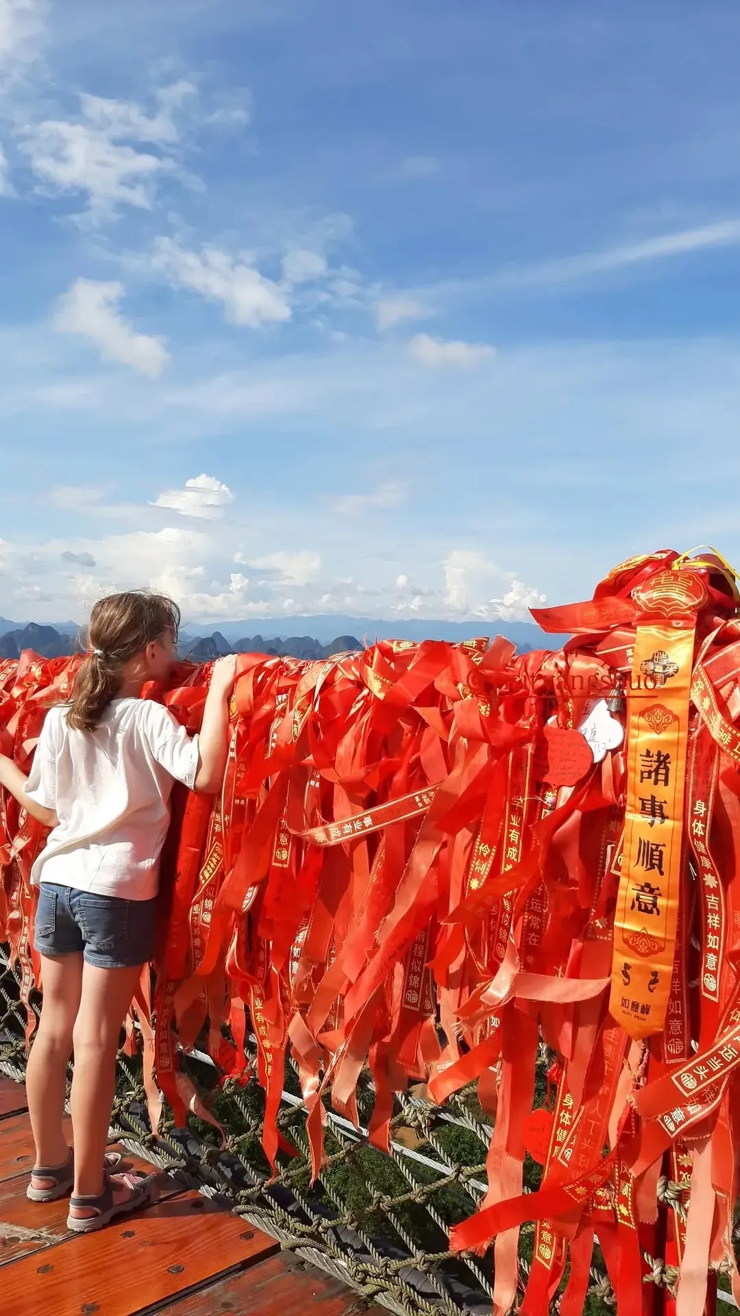 Red wish ribbons tied along the railing at Ruyi Peak, Yangshuo, China